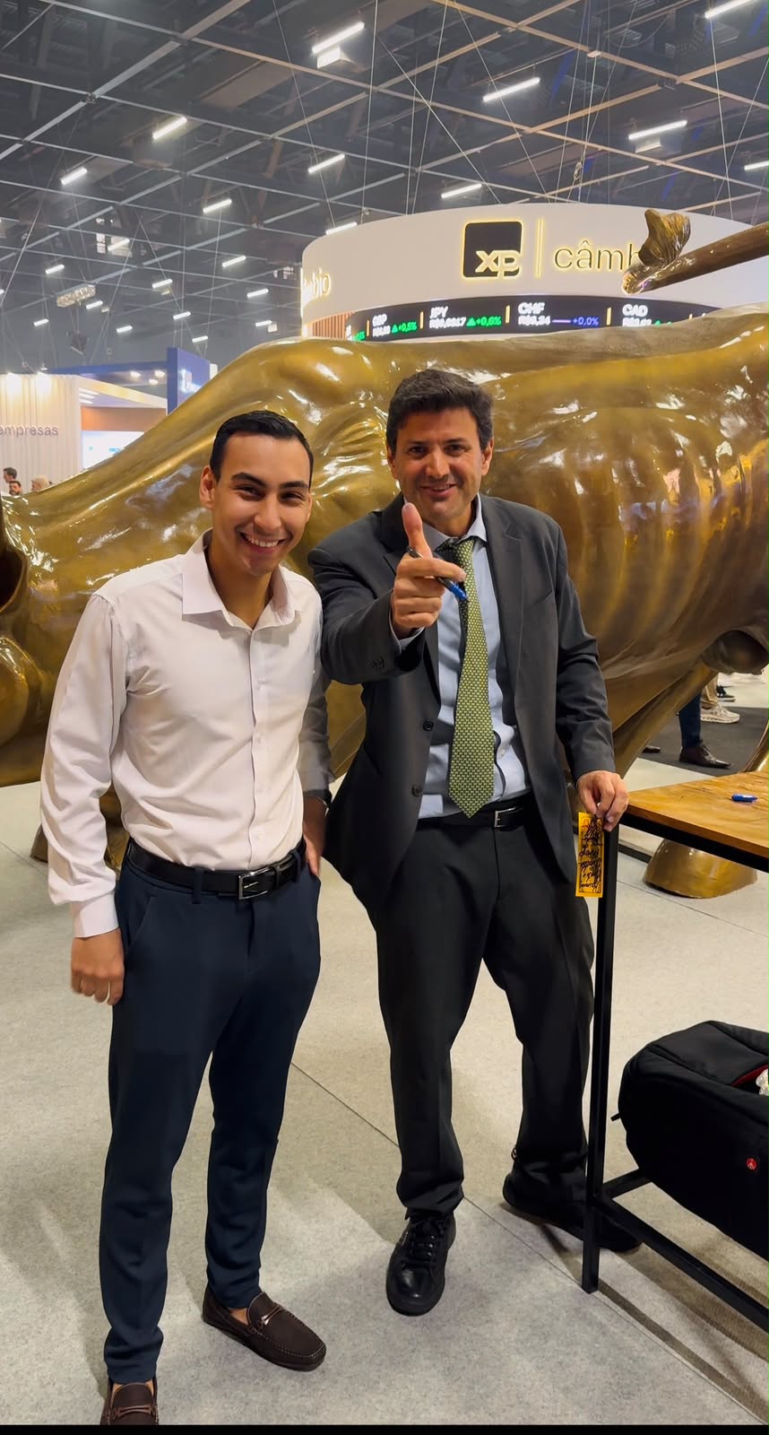 Kauan Pacini ao lado do touro dourado da XP